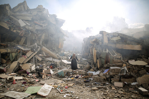 GAZA CITY, GAZA - OCTOBER 19: A resident gets upset as she walks amid near the rubble of residential buildings after Israeli airstrikes at al-Zahra neighborhood in Gaza Strip on October 19, 2023. (Photo by Mustafa Hassona/Anadolu via Getty Images)